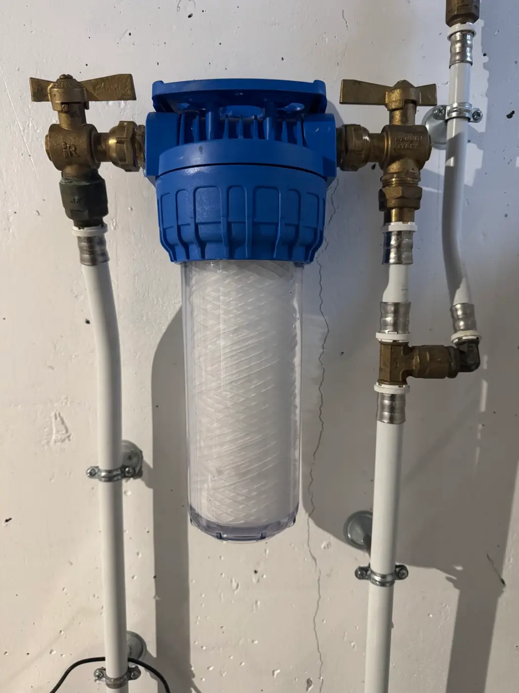 Filtre à eau et raccordements en amont d’une installation de traitement de l’eau